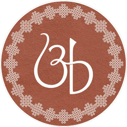 amaa's benne monogram — an 'ab' ligature in a kasuti-embroidered terracotta circle